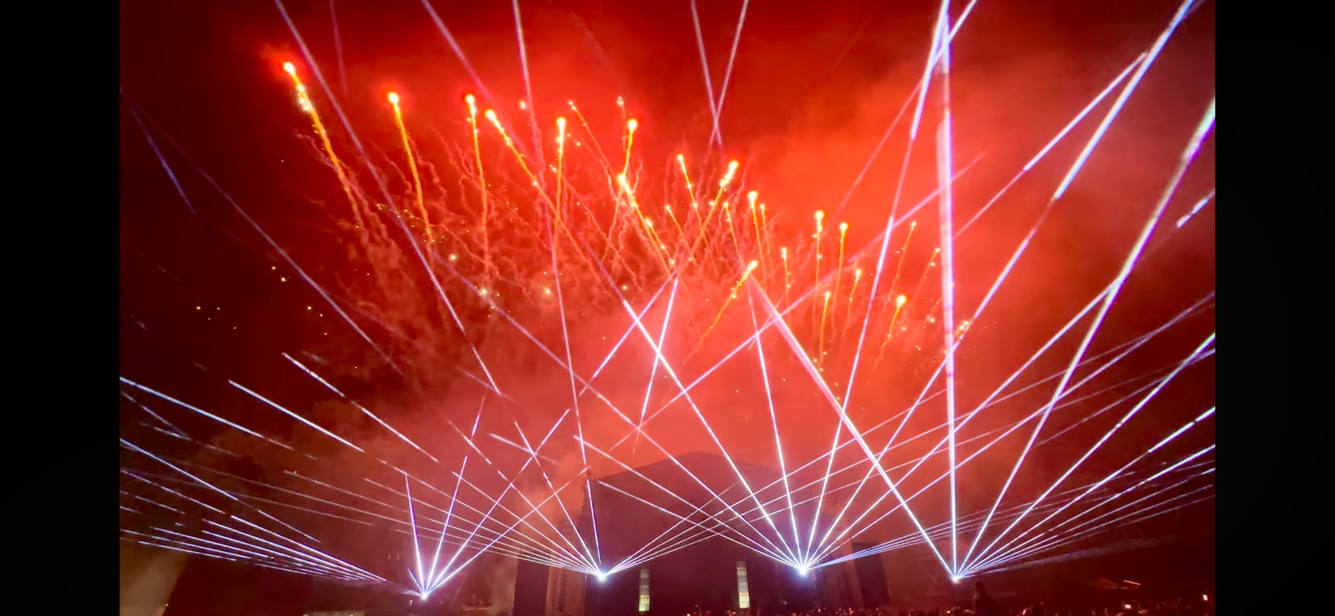 Rot illuminierte Lasershow mit Pyrotechnik über der Bühne