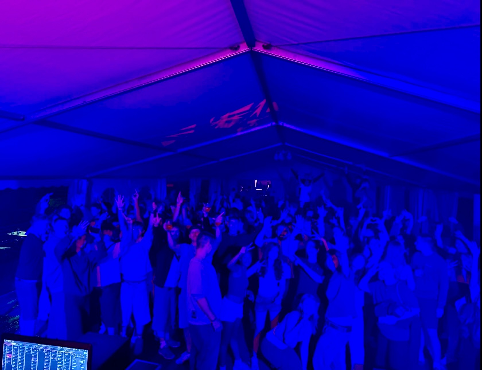 Feiernde Gäste im Festzelt bei blauem Licht