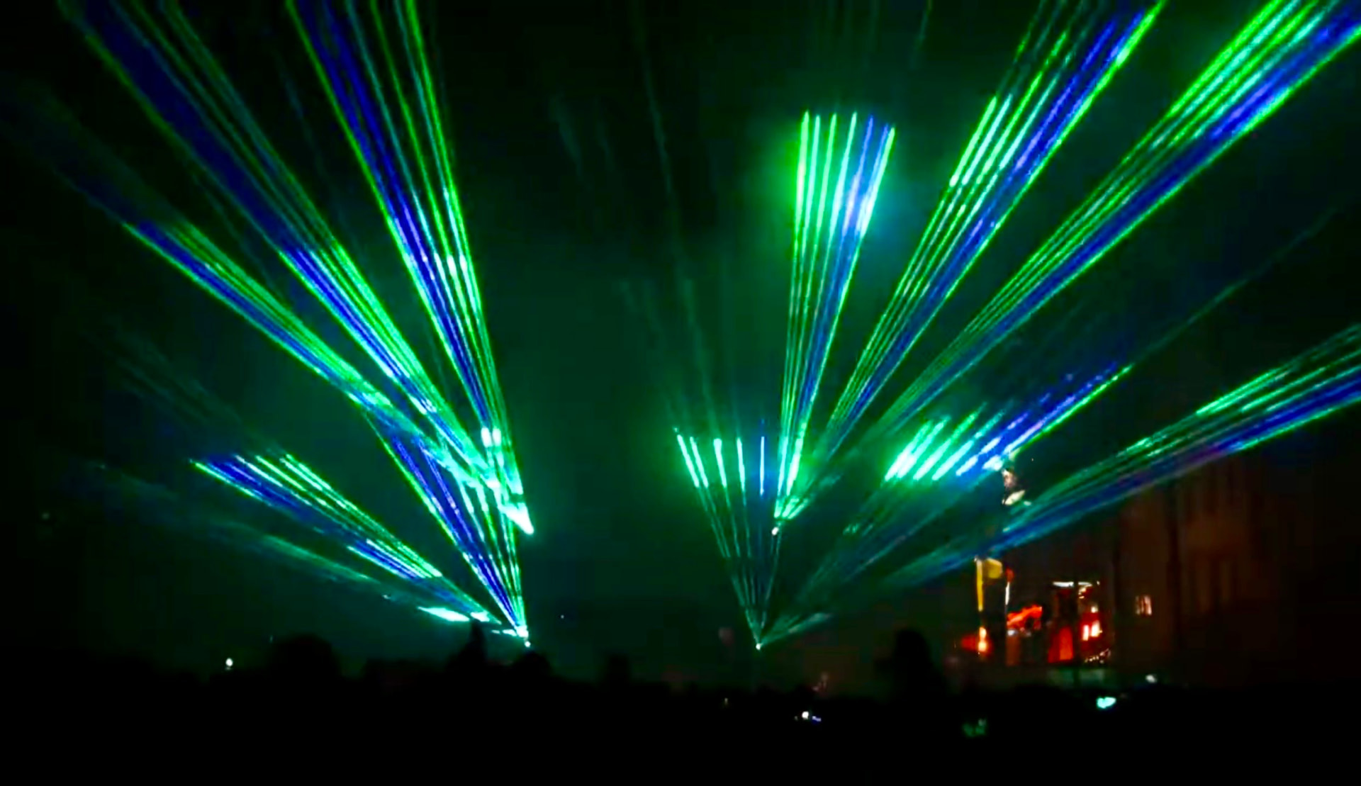 Lasershow mit grünen und blauen Strahlenfächern